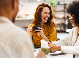 Friends smiling while enjoying coffee