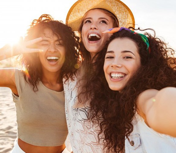 Three friends posing for a photo on the beach