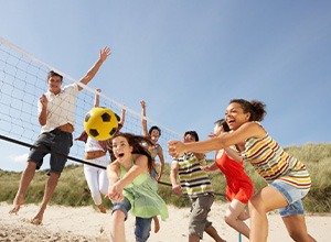 Group of friends playing volleyball at the beach