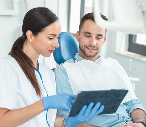 Female dentist showing male patient a tablet