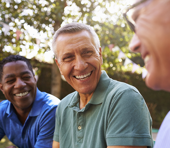 Three men sitting in a row and smiling