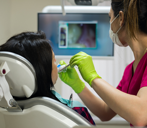 Dentist examining patient's teeth with intraoral camera