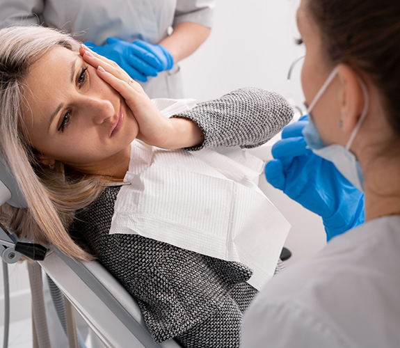 Woman with tooth pain visiting emergency dentist in West Palm Beach