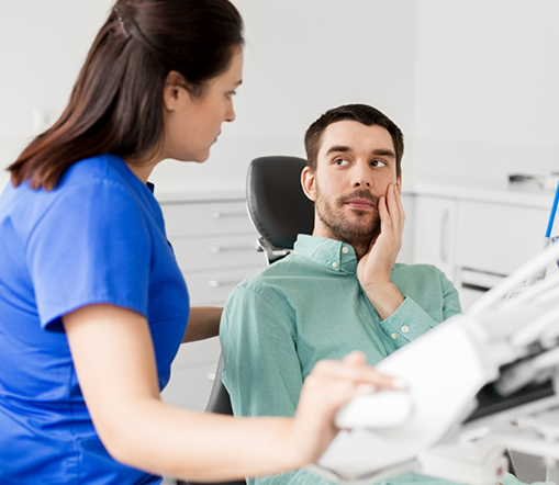 Female dentist and male dental patient with tooth pain