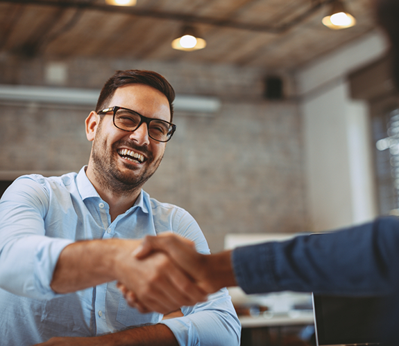 Man with glasses shaking another man's hand