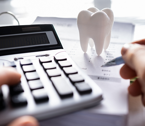 Using calculator and pen to figure out dental costs