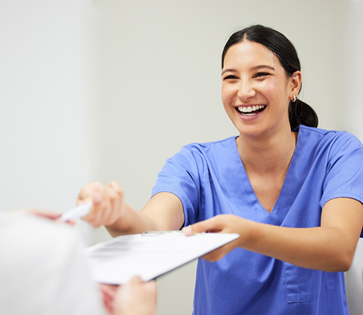 Female dentist handing patient clipboard and pen