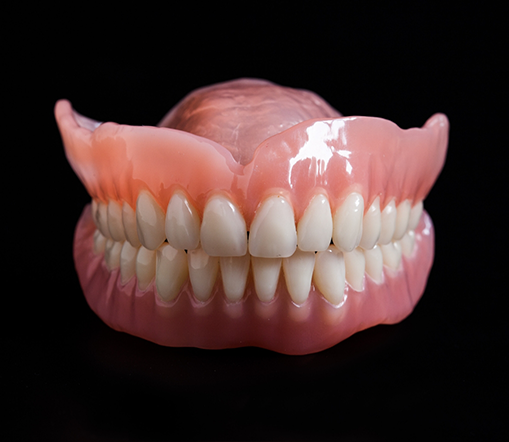 Close up of dentures on a black background