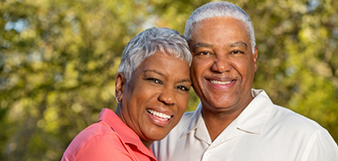 Senior man and woman standing outside smiling