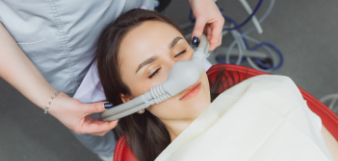 Placing mask on patient's nose for sedation dentistry