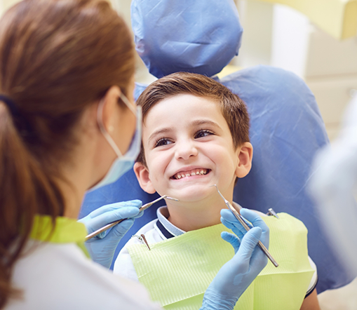 Little boy smiling up at dentist during checkup