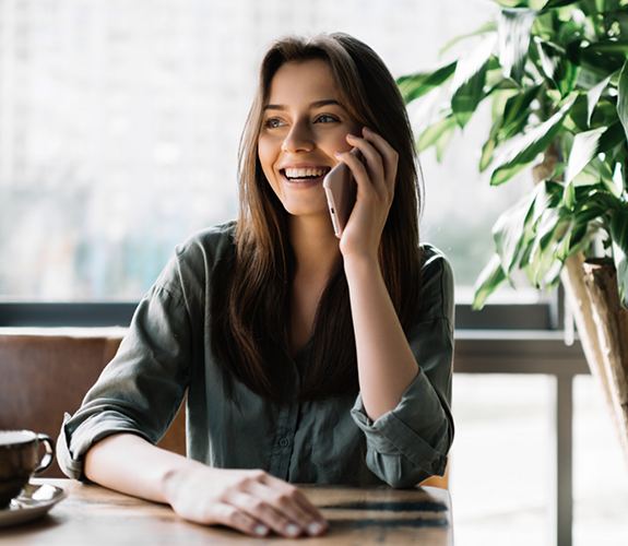 Woman sitting at desk and talking on phone