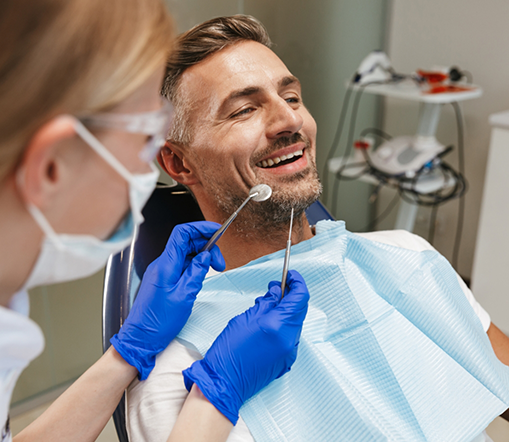 Man sitting back in dental chair and smiling