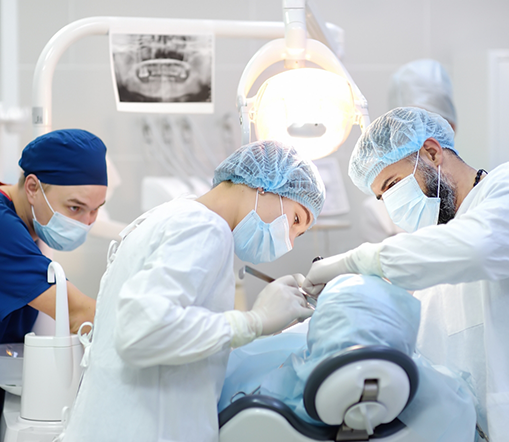 Dental team with masks performing tooth extraction in West Palm Beach